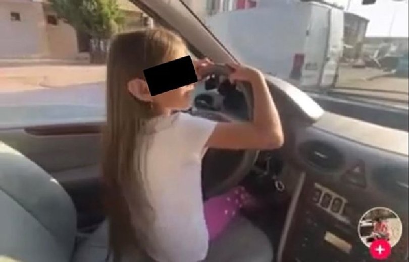 Момиченце на видима възраст от 7-8 години шофира кола точно
