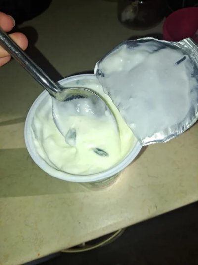 Майка отвори кофичка кисело мляко за да нахрани детето си