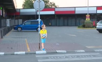 Мъж насъсква кучето си срещу декоративни фигури на пешеходци