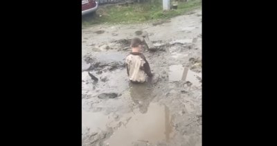 Вижте великата руска кочина: Дете затъна в метър кал посред улицата (ШОК ВИДЕО)