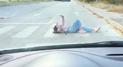 Мания или протест: Млада благоевградчанка легна на пътя с телефон в ръка